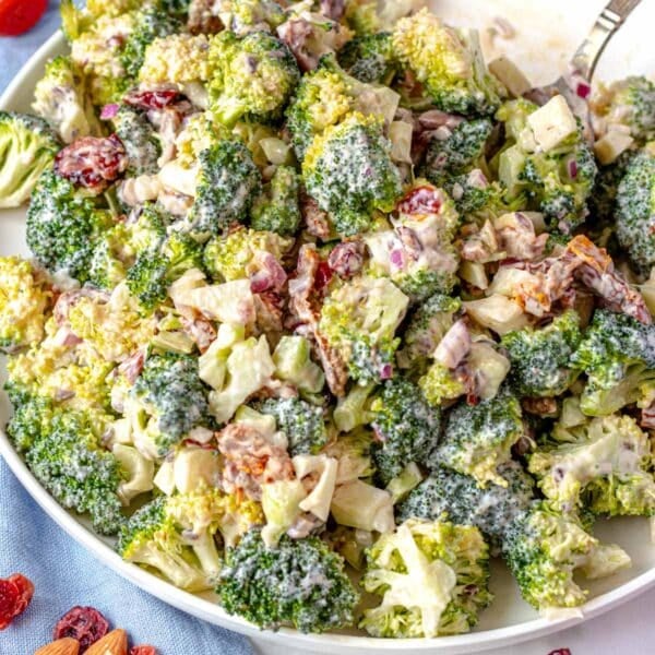Broccoli salad on a big white plate with a spoon