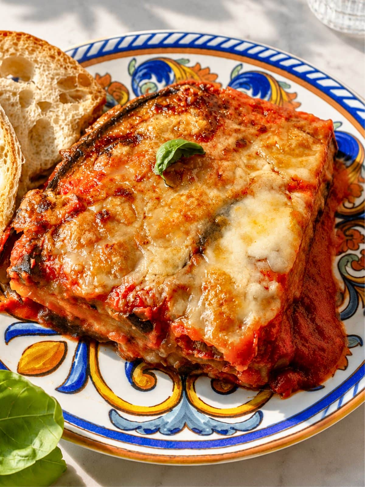 Close-up of sliced and layered Eggplant Parmigiana with roasted eggplant, mozzarella, and Parmesan cheese.
