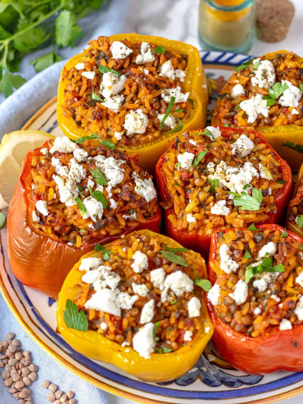 Mediterranean stuffed bell peppers with rice and lentils, baked until golden and topped with fresh parsley.