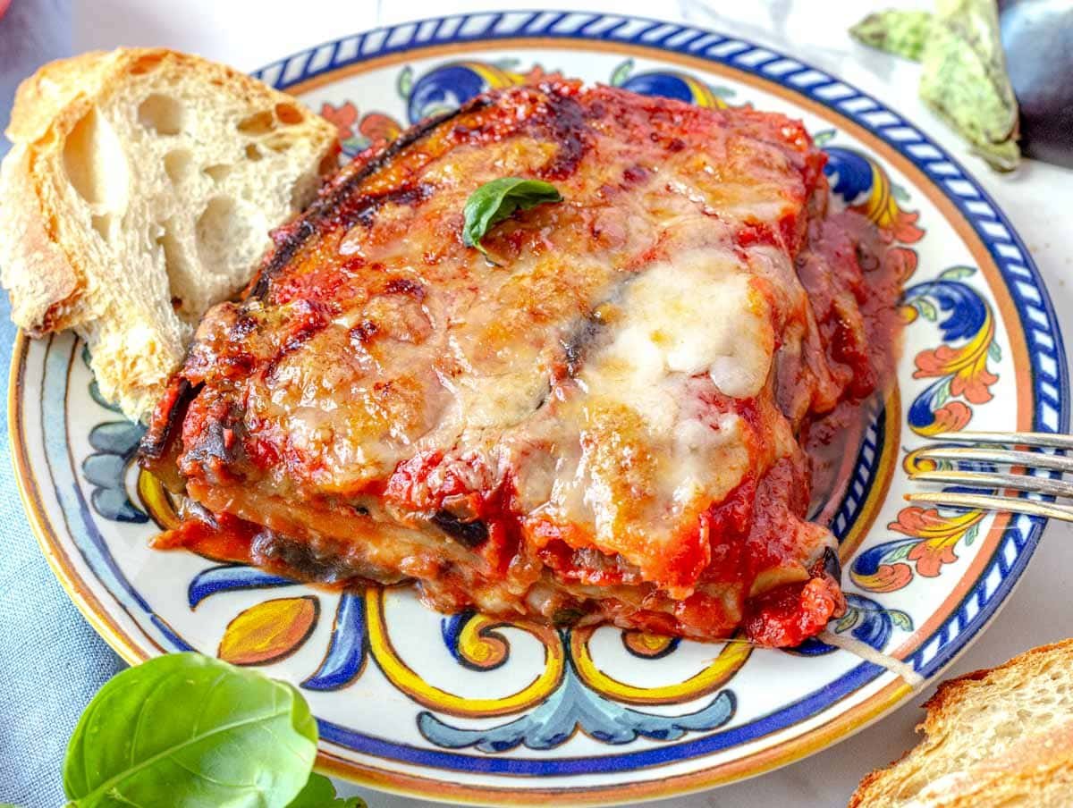 Parmigiana with homemade bread on a blue plate