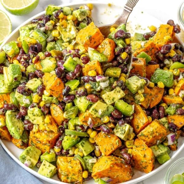 black bean salad with avocado, corn and sweet potato on a white plate