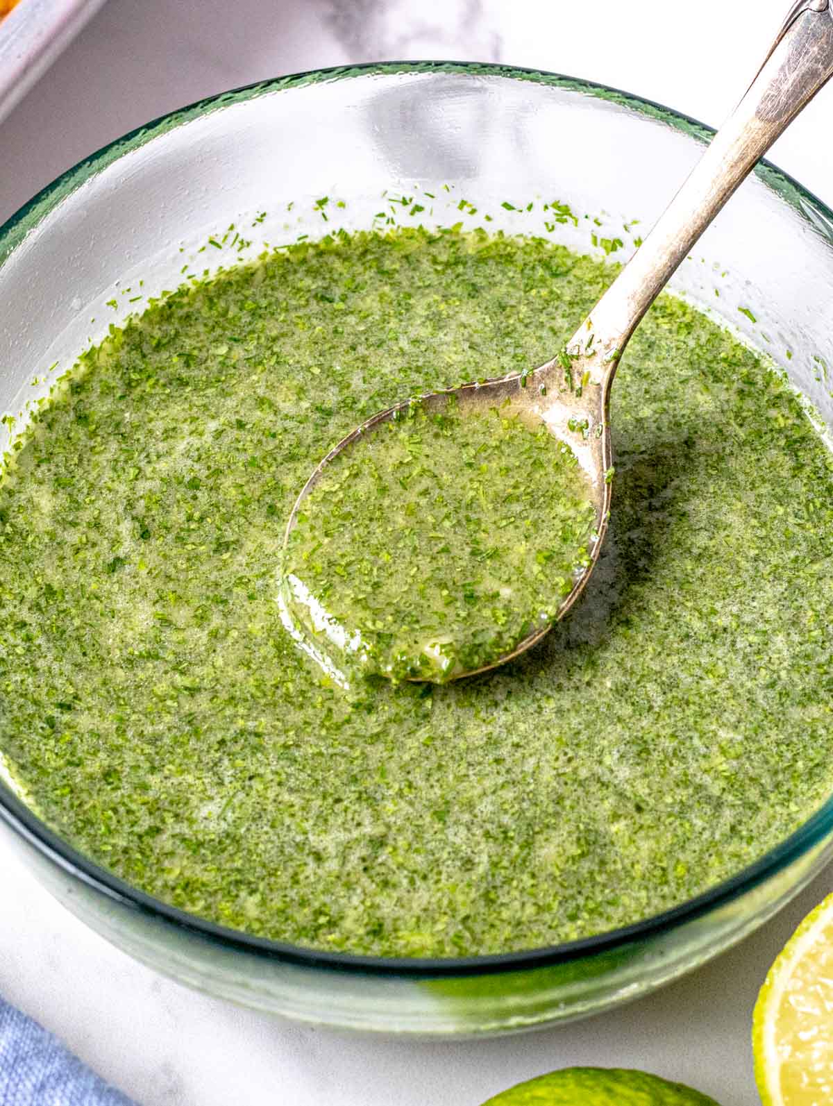 cilantro lime dressing in a glass bowl with a silver spoon