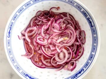 pickled red onions marinating in a bowl.