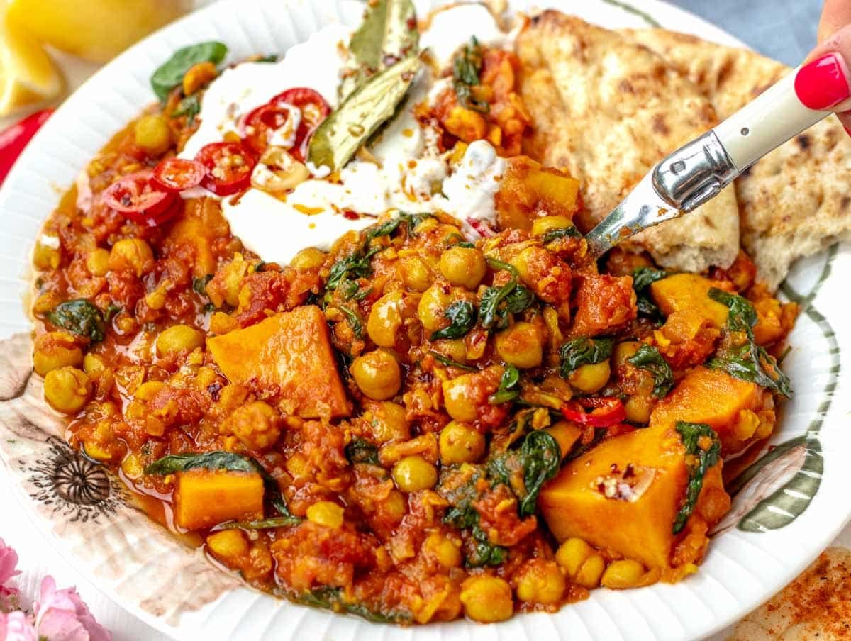 Chickpea stew with female hand and a spoon