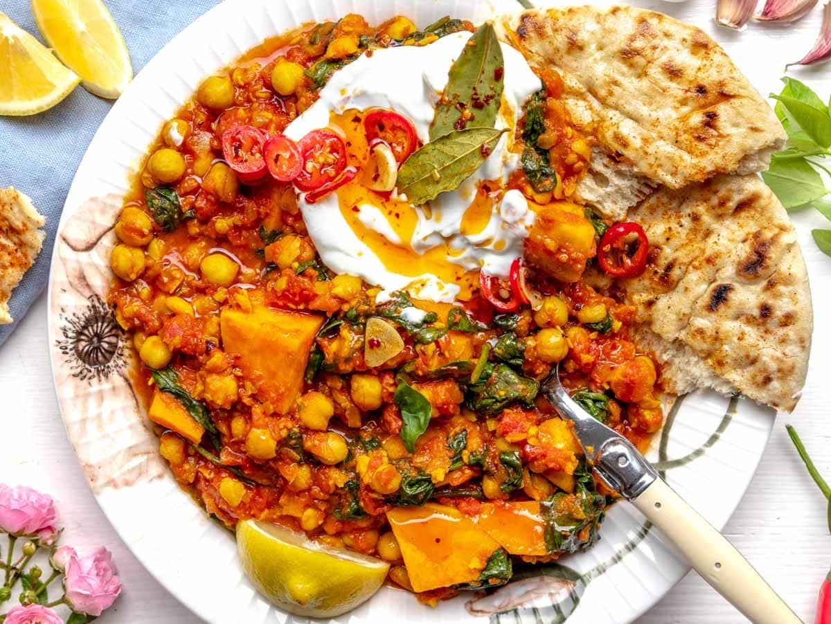 Chickpea stew with yogurt and chili oil on a plate with flowers