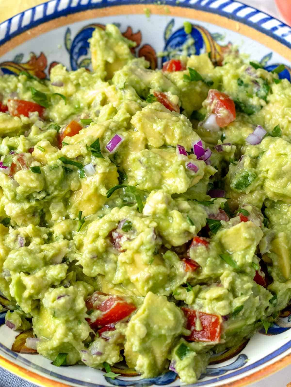 Guacamole with tomatoes served in a bowl