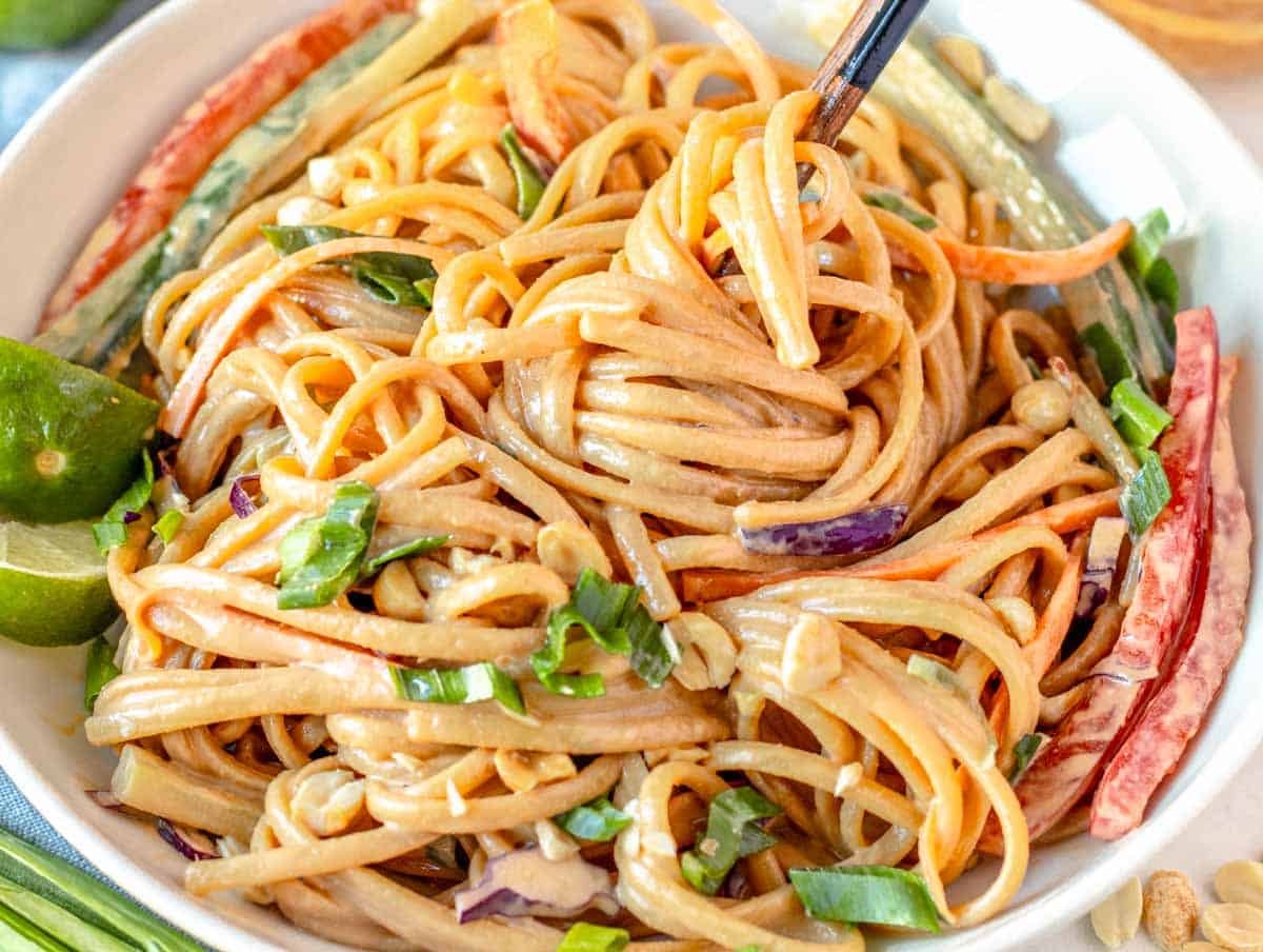 Creamy peanut noodles in a white bowl