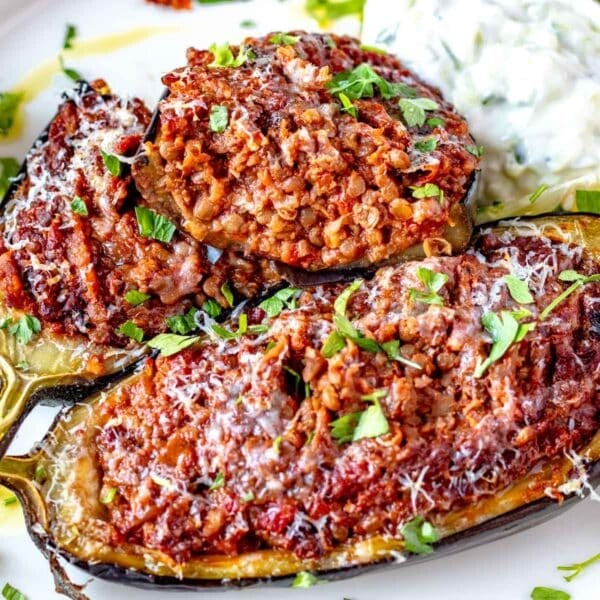 Stuffed eggplant cut into half with parmesan cheese and parsley