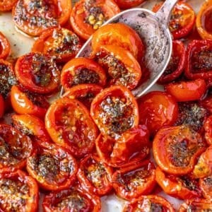 Tomato confit with tender roasted tomatoes and basil in natural window light.