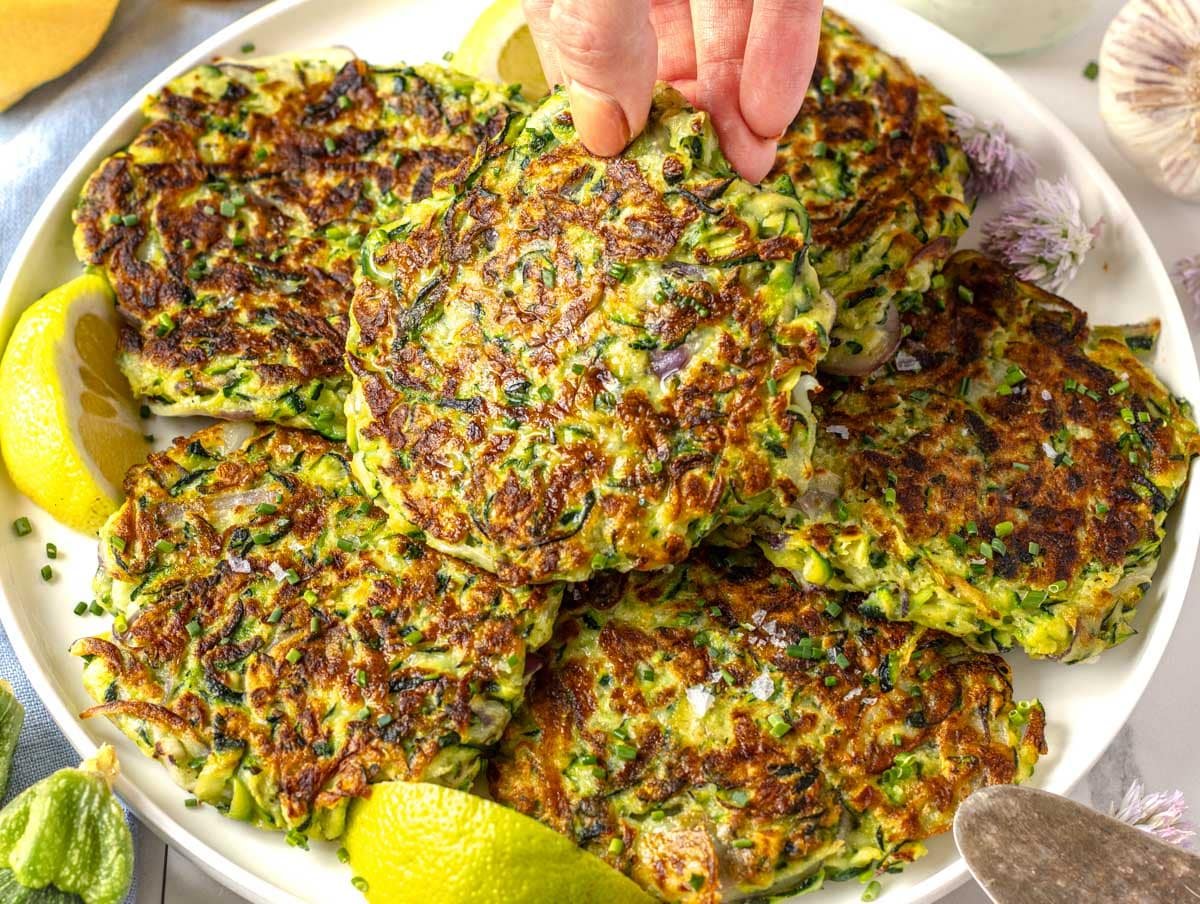 Zucchini fritters and a female hand