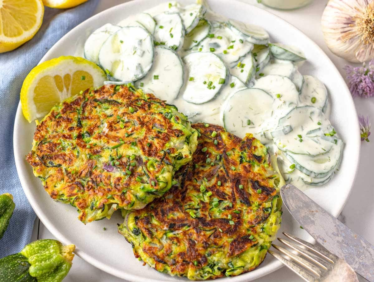Zucchini fritters on a plate with a knife and a fork