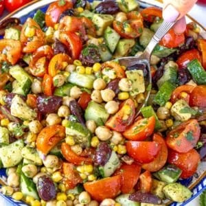 chickpea salad with hand holding a silver spoon