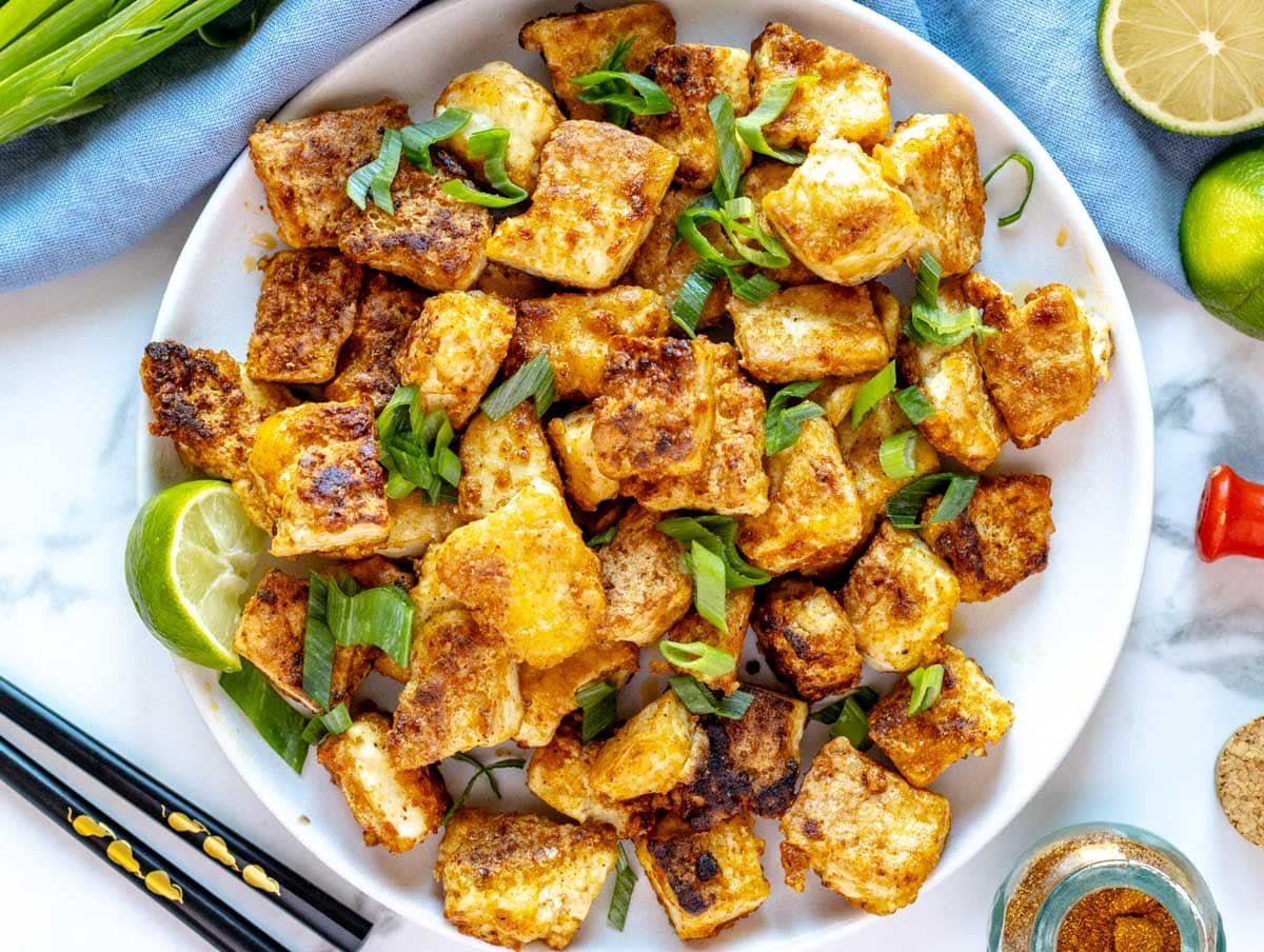 fried tofu on a pate topped with spring onions and lime