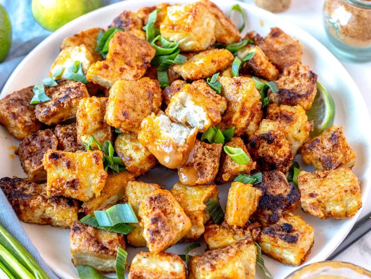 fried tofu bit into half and served on a white plate