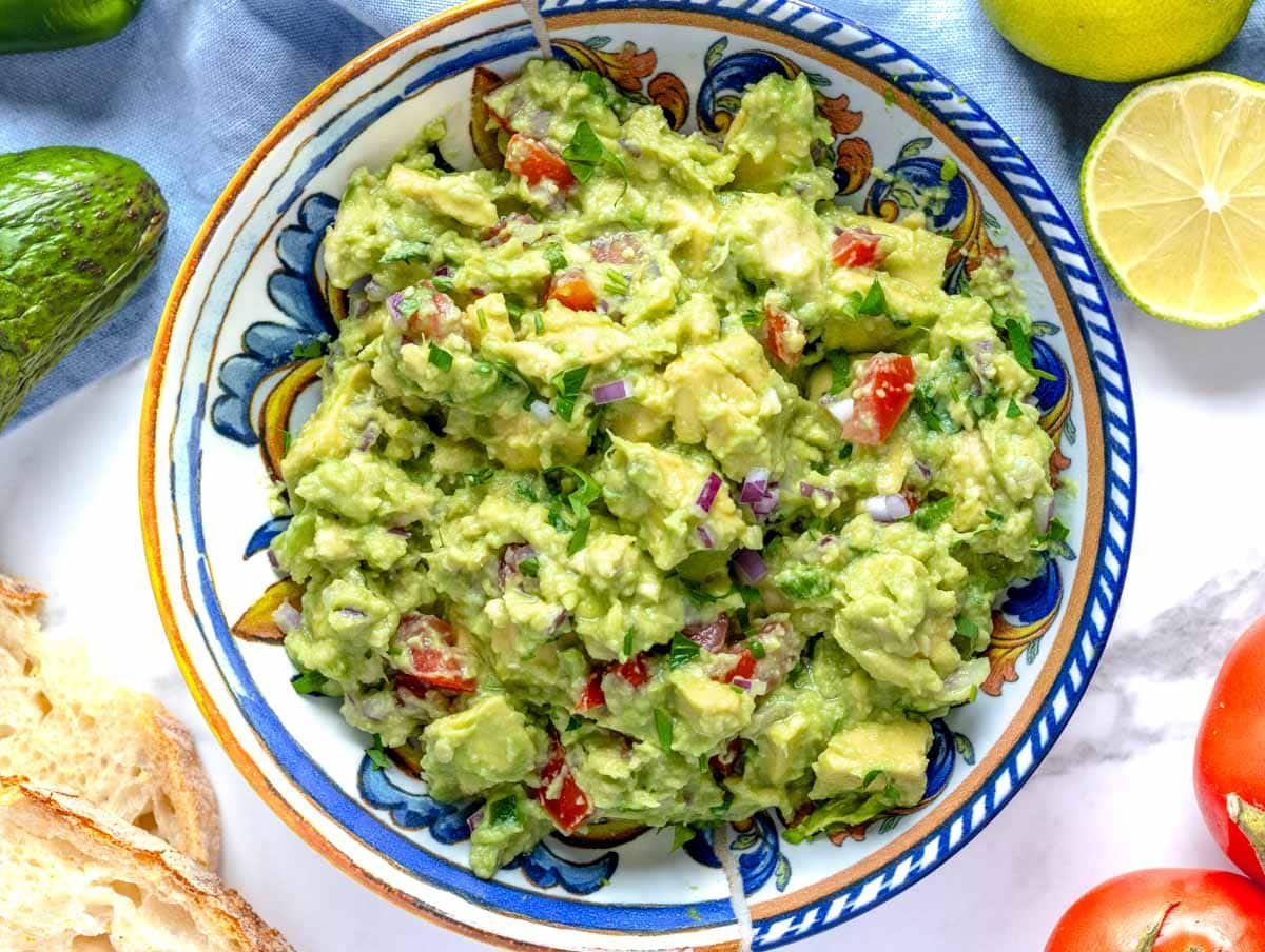 guacamole in a bowl with bread on the side