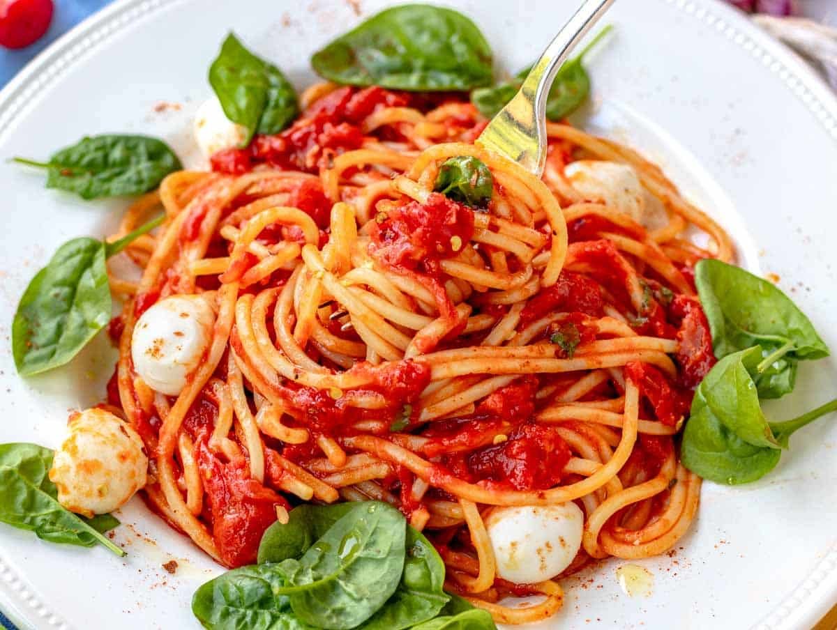 pomodoro pasta with a fork and mozzarella balls