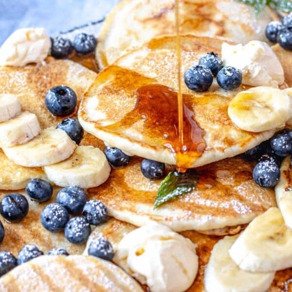 vegan pancakes with blueberries, banana, and maple syrup