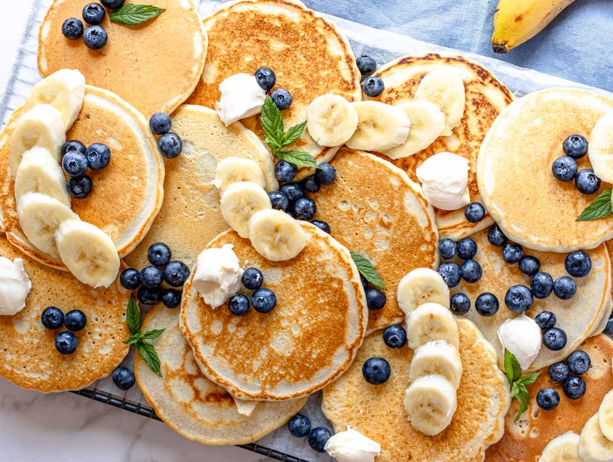 vegan pancakes on a platter with banana and blueberries