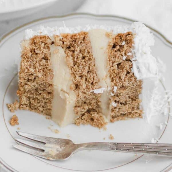 a slice of vegan coconut cake on a white plate