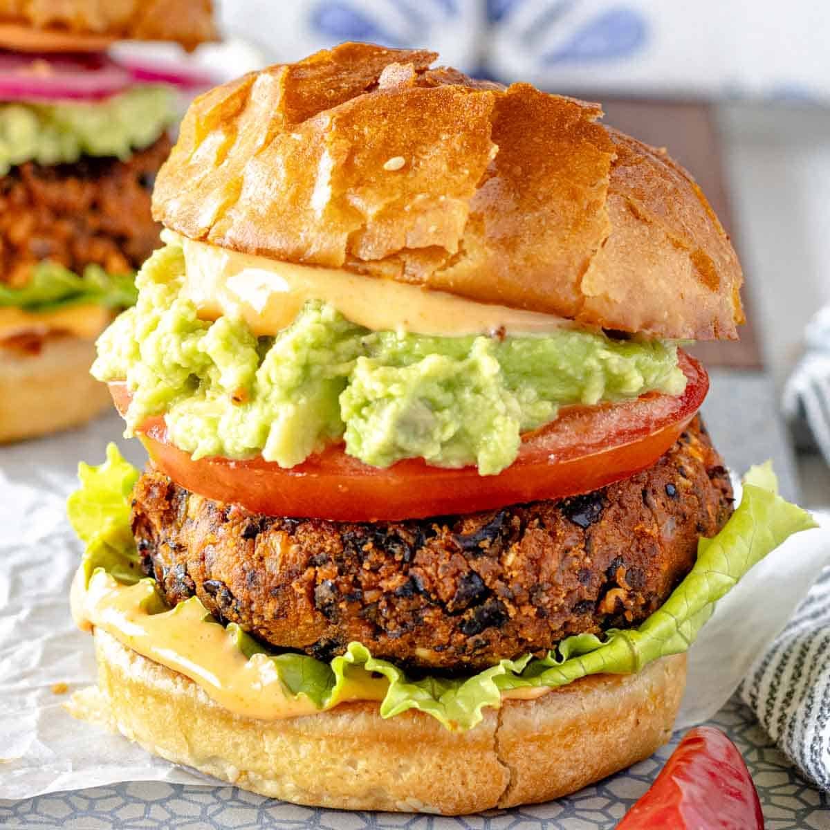 Black bean burger with guacamole and tomato in a bun