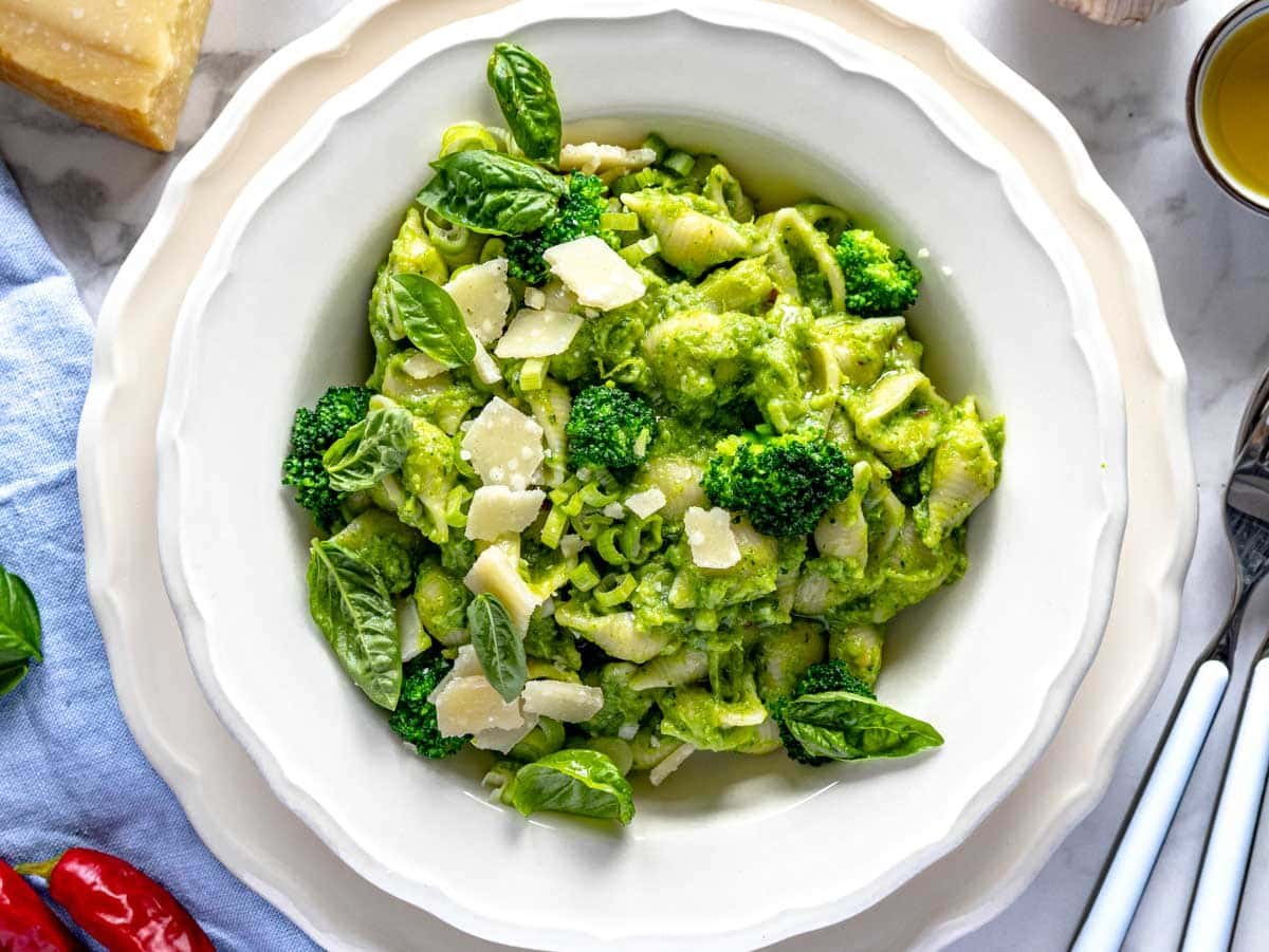 plated broccoli pasta with a garnishing of basil leaves and shaved parmesan