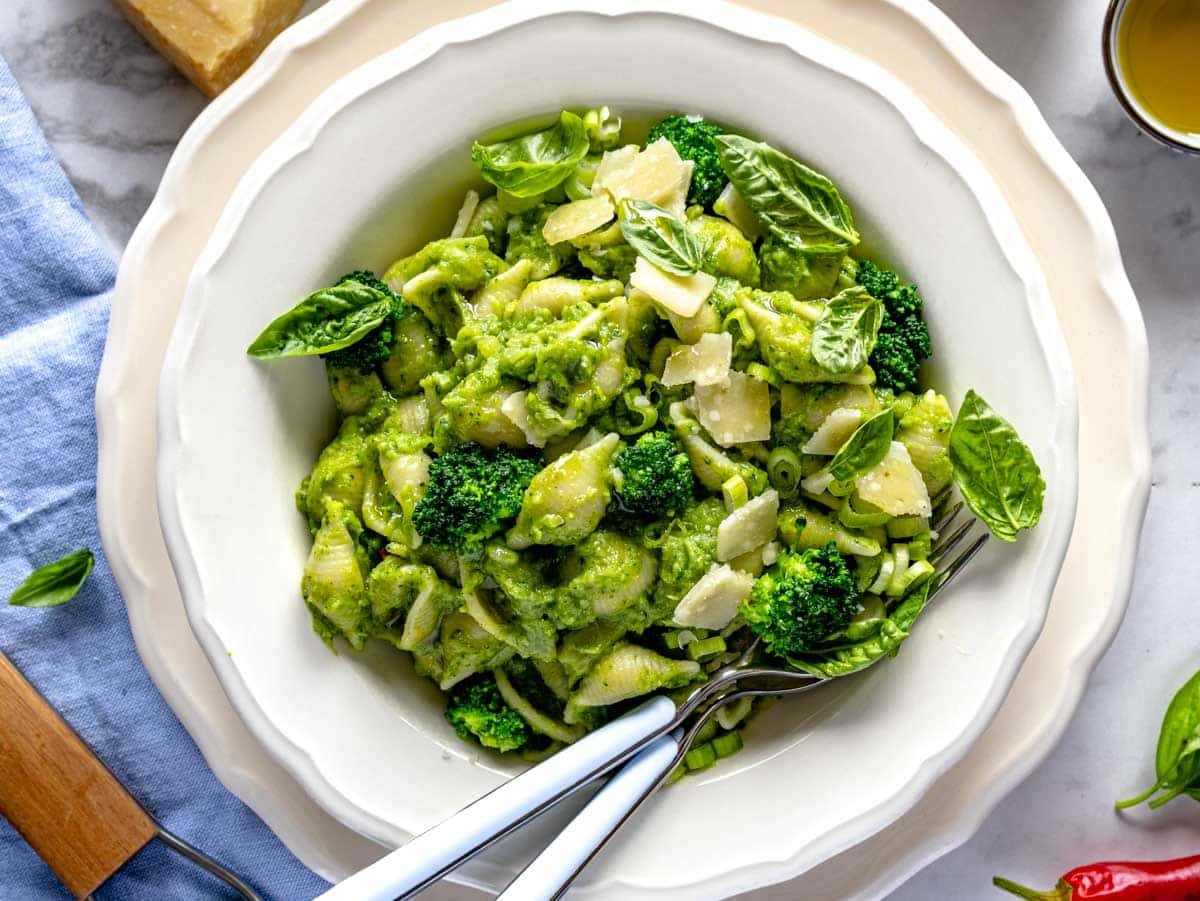 Creamy broccoli pasta with basil and parmesan in a white plate