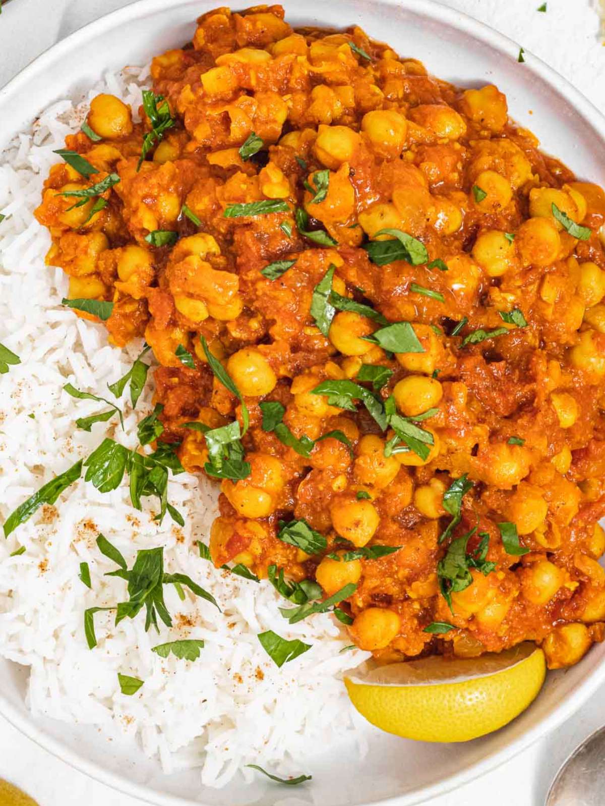 Close up of chana masala with chickpeas in rich spiced tomato sauce and rice.
