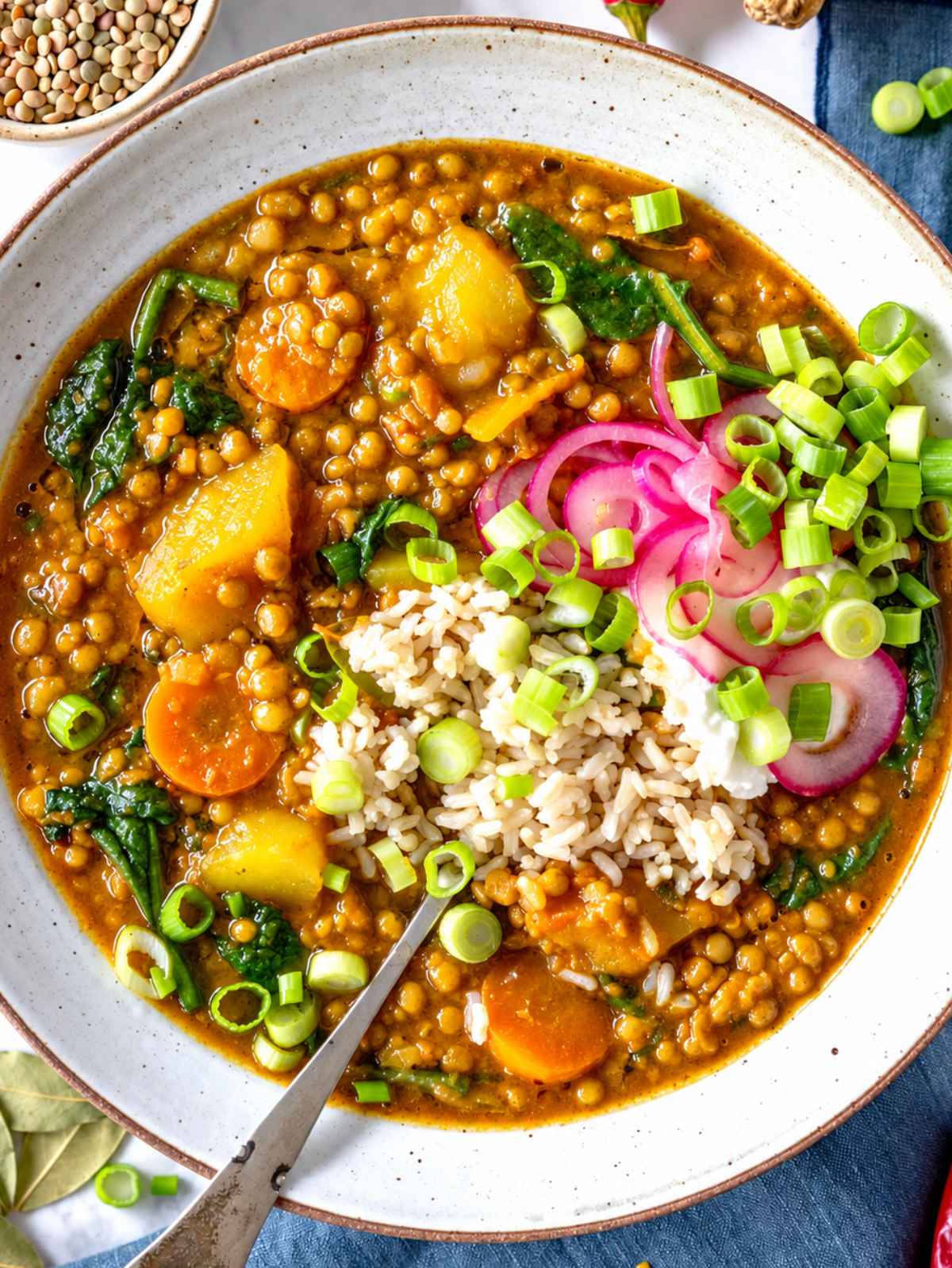 Curry lentil soup with lentils, potatoes, carrots, kale, rice, and herbs.