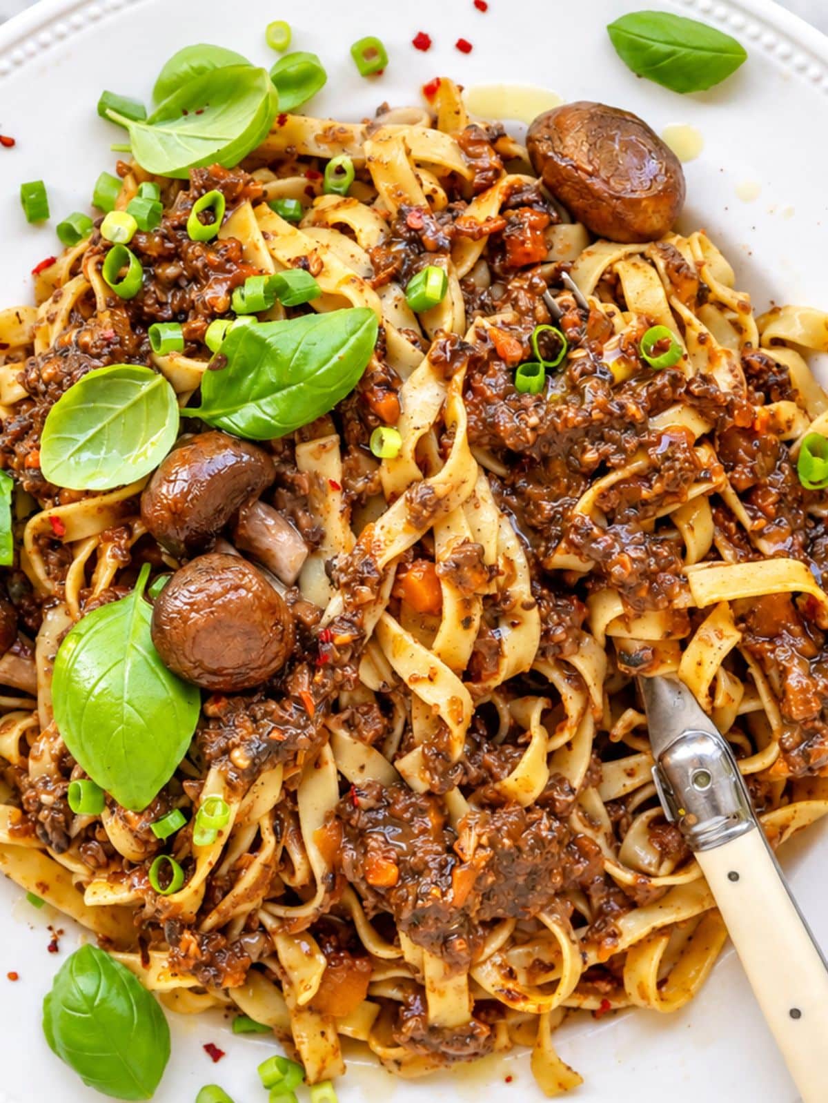 Flat lay of glossy fettuccine coated in thick mushroom ragu.