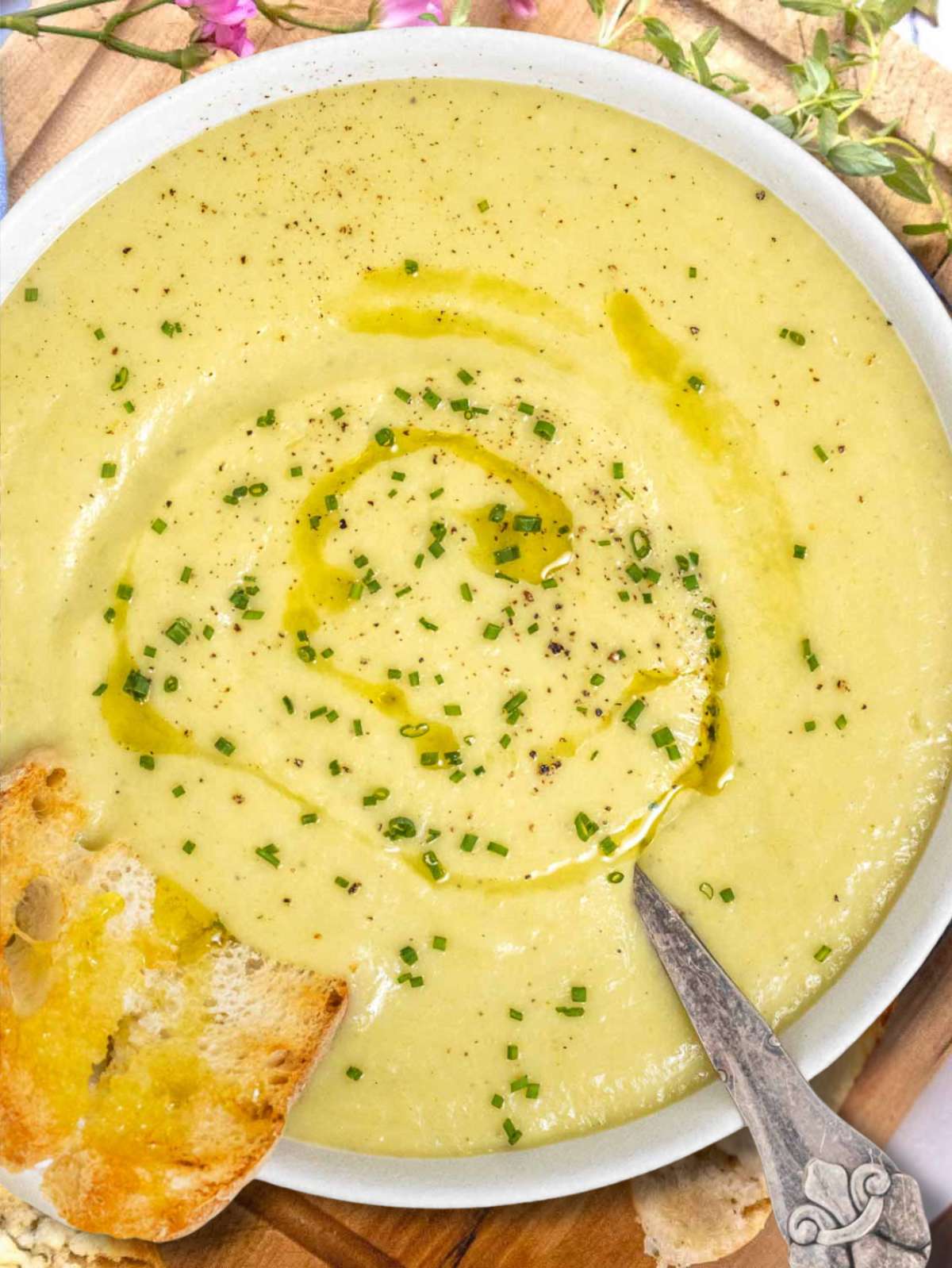 Healthy potato leek soup with skyr photographed from above with bread on the side.