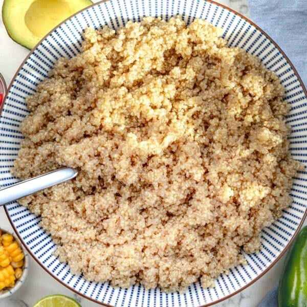 cooked quinoa in a blue bowl with a silver spoon