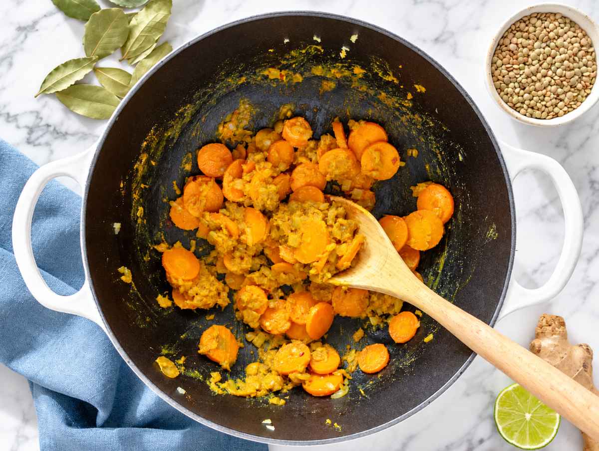 Step 1 Onion and carrots sauteฬing with garlic, ginger, curry powder, and spices.