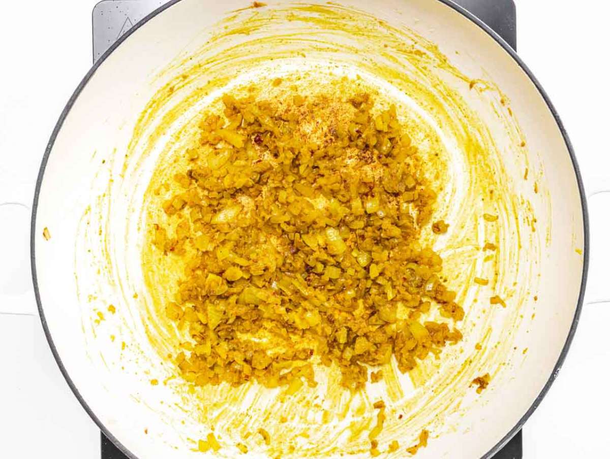 Step 1 Onion garlic and ginger sauteฬing in a skillet with red pepper flakes and spices.