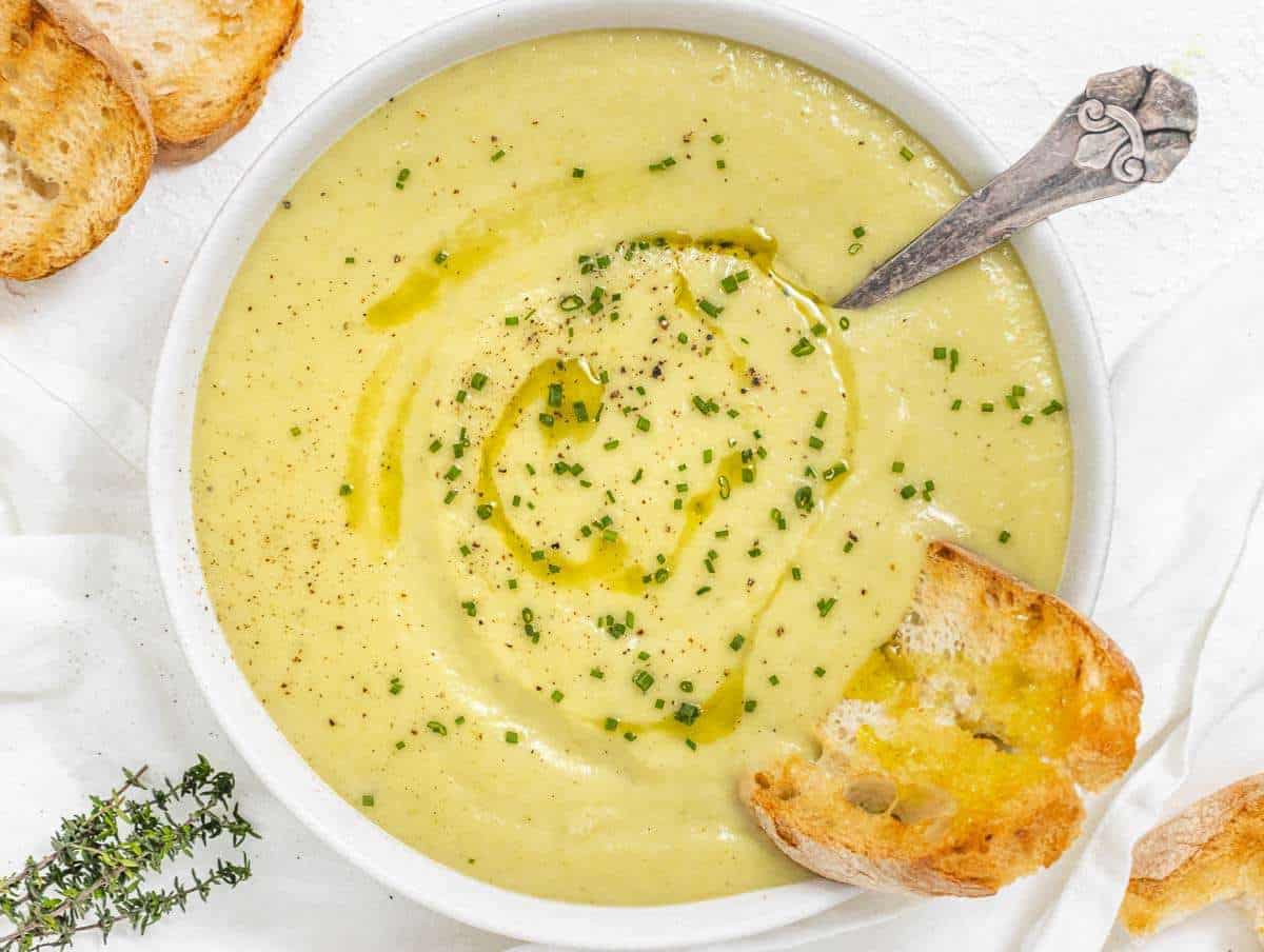 Step 4 Bowl of potato leek soup garnished with chives and a drizzle of olive oil.