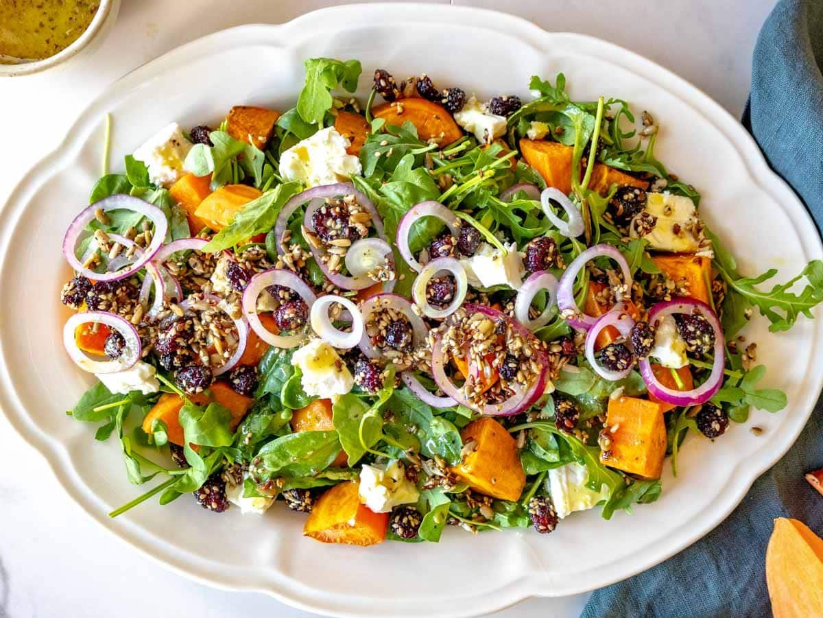 how to assemble a sweet potato salad on a bed of leafy greens