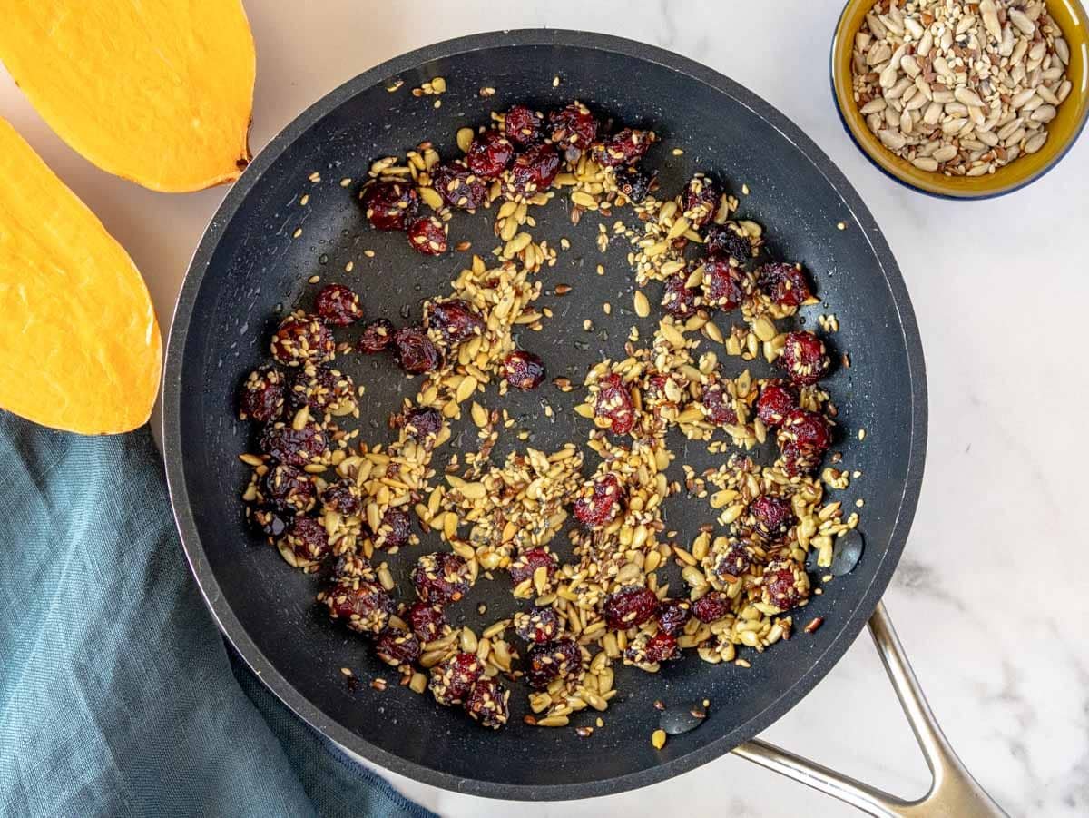 toasted seeds and cranberries on a non-stick pan