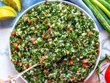 Tabbouleh salad with female hand holding a silver spoon