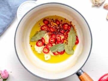 making tadka in a saucepan with oil, aromatics and spices