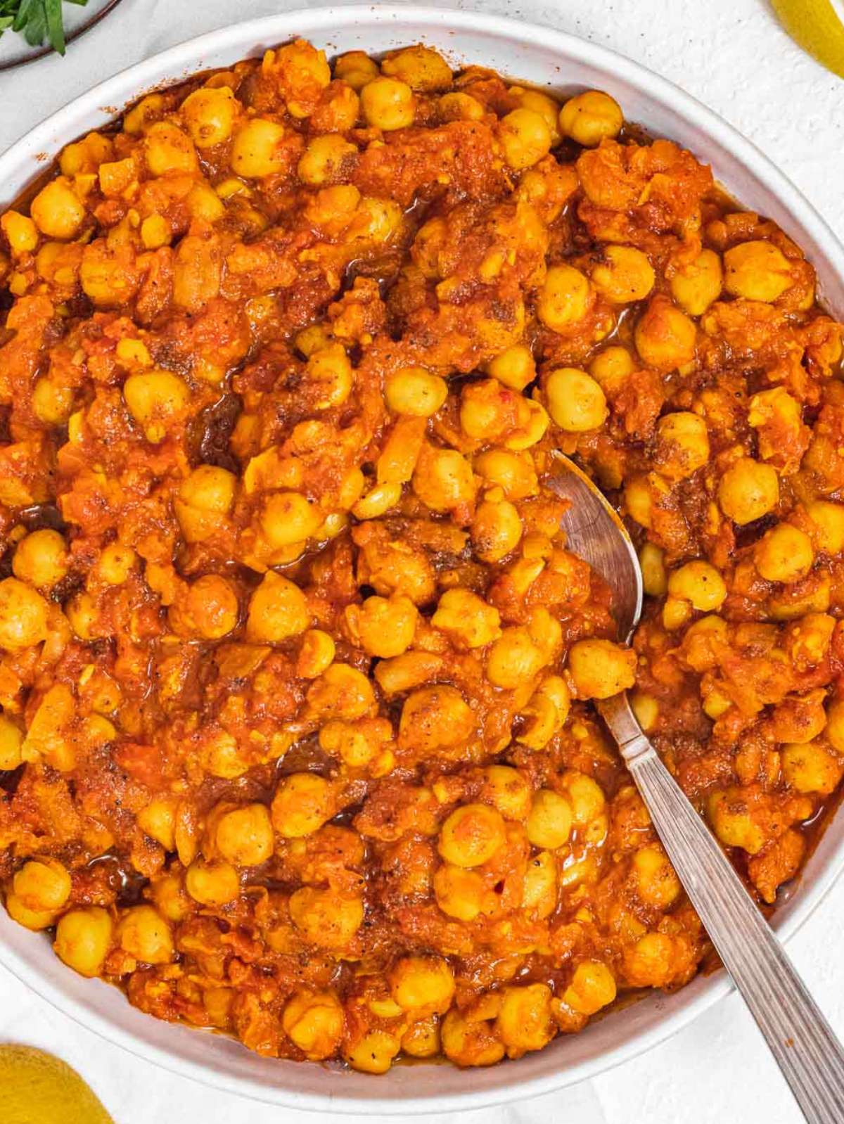 Top down view of chana masala served with rice and cilantro garnish.