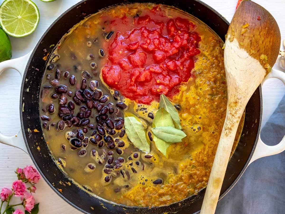 balck beans, canned tomatoes, bay leaves, and vegetable broth added to the pot