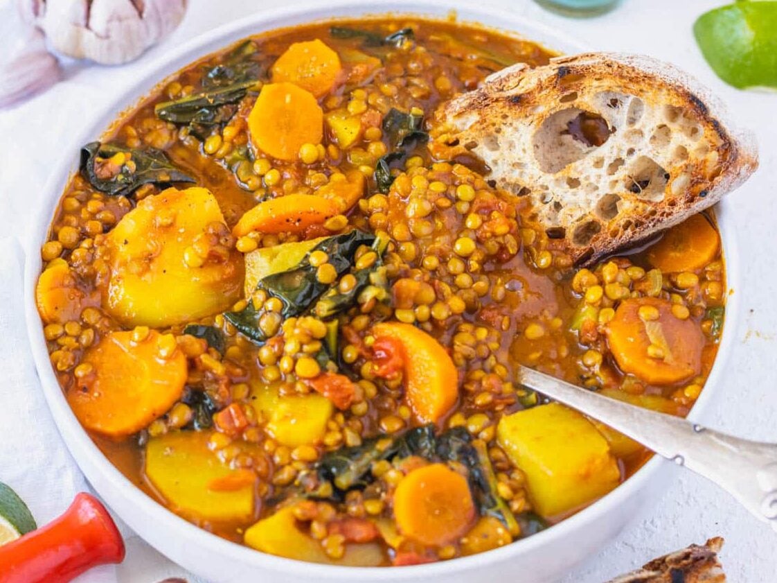 curry lentil soup with sourdough bread and a spoon