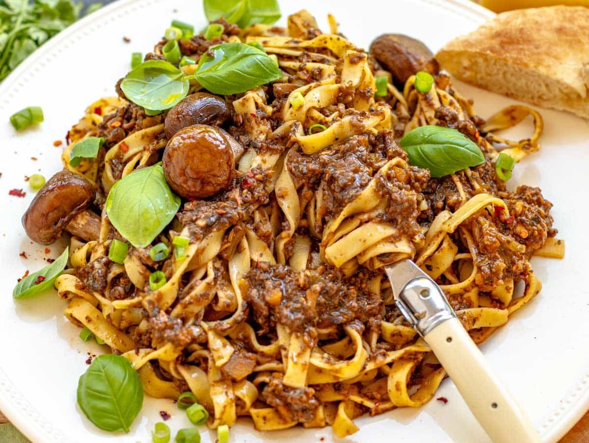 mushroom bolognese with fresh basil and a fork