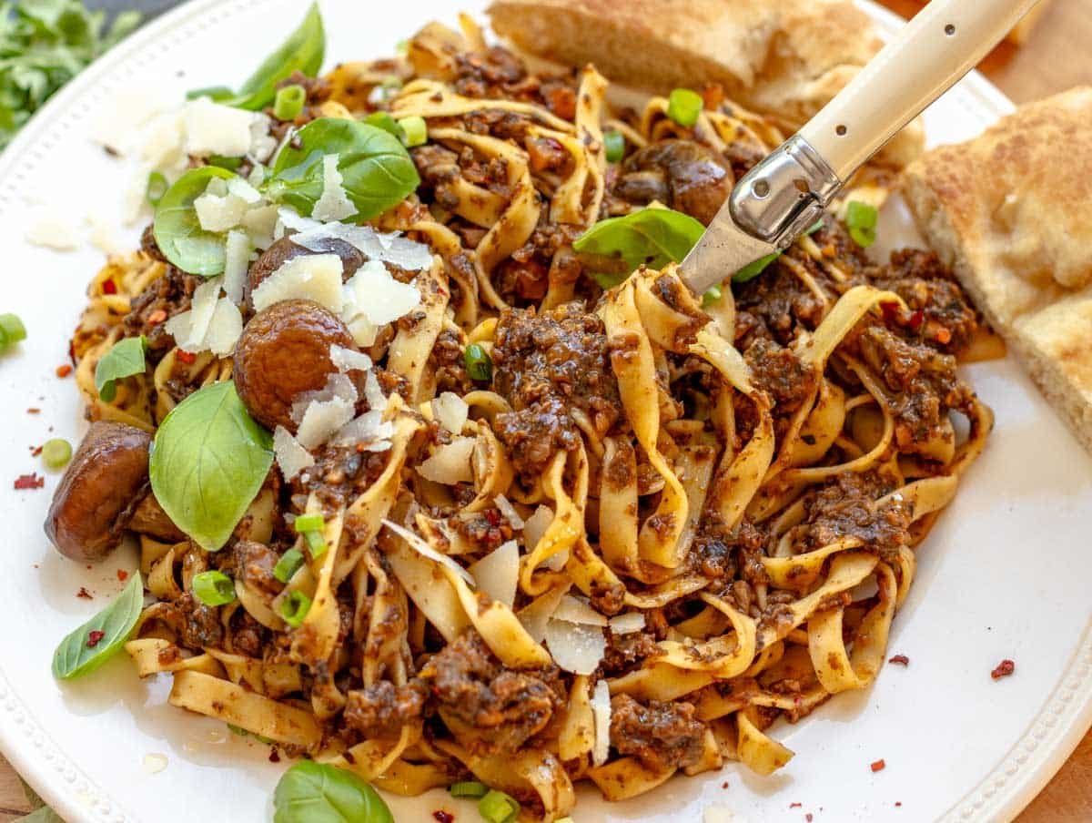 mushroom bolognese with a fork and parmesan cheese