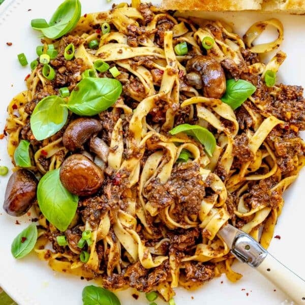 mushroom bolognese with a fork and fresh basil