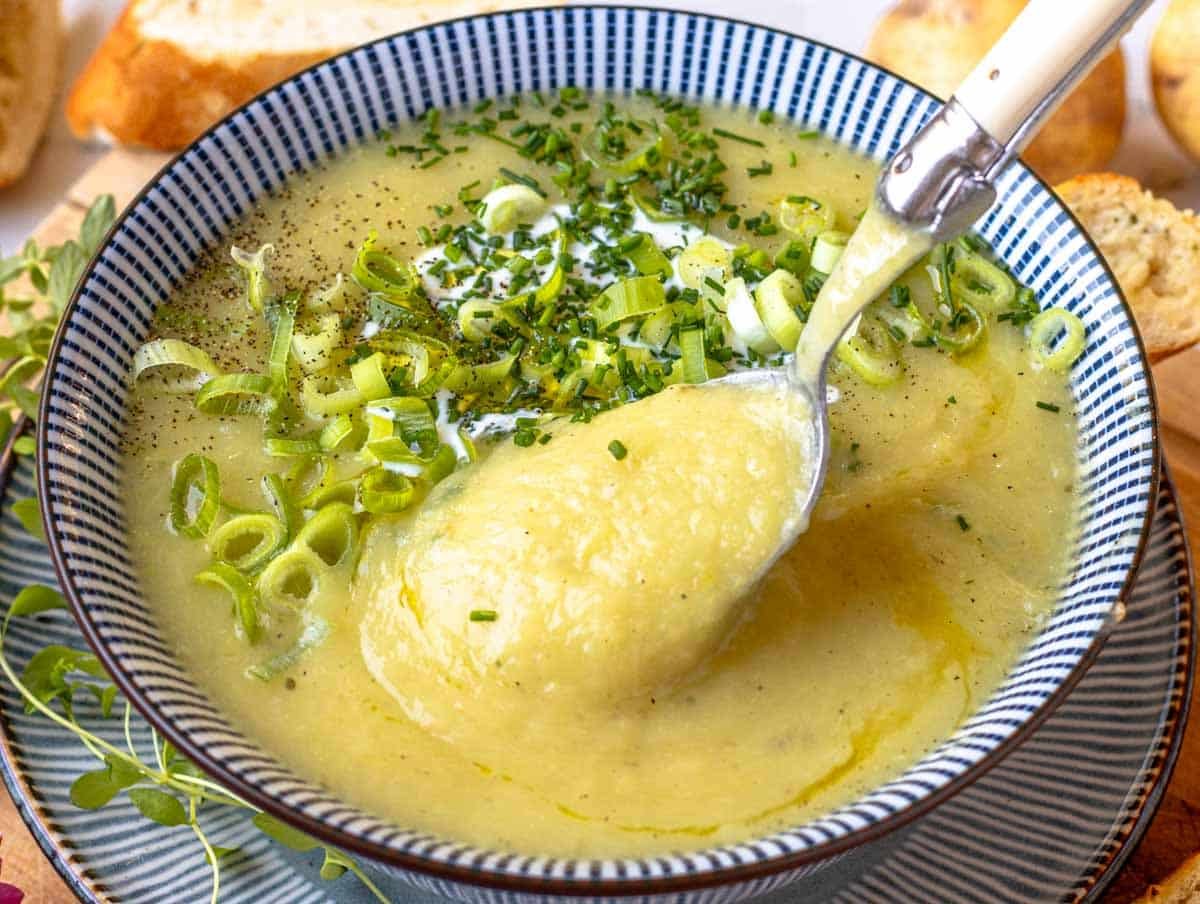 potato leek soup with hand holding a spoon