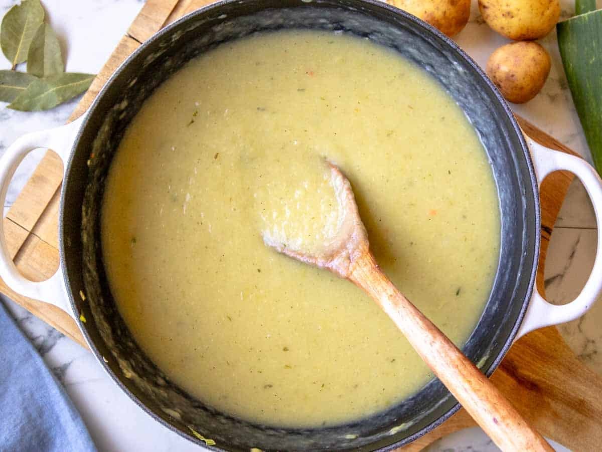 potato leek soup after blending with a wooden spoon