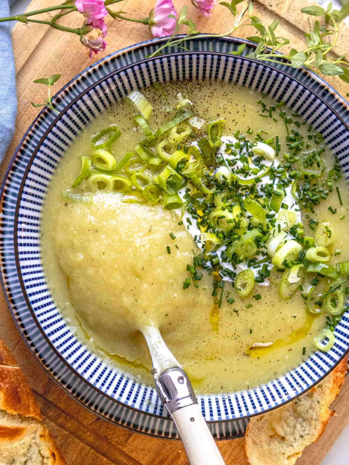 potato leek soup in a blue bowl with a spoon