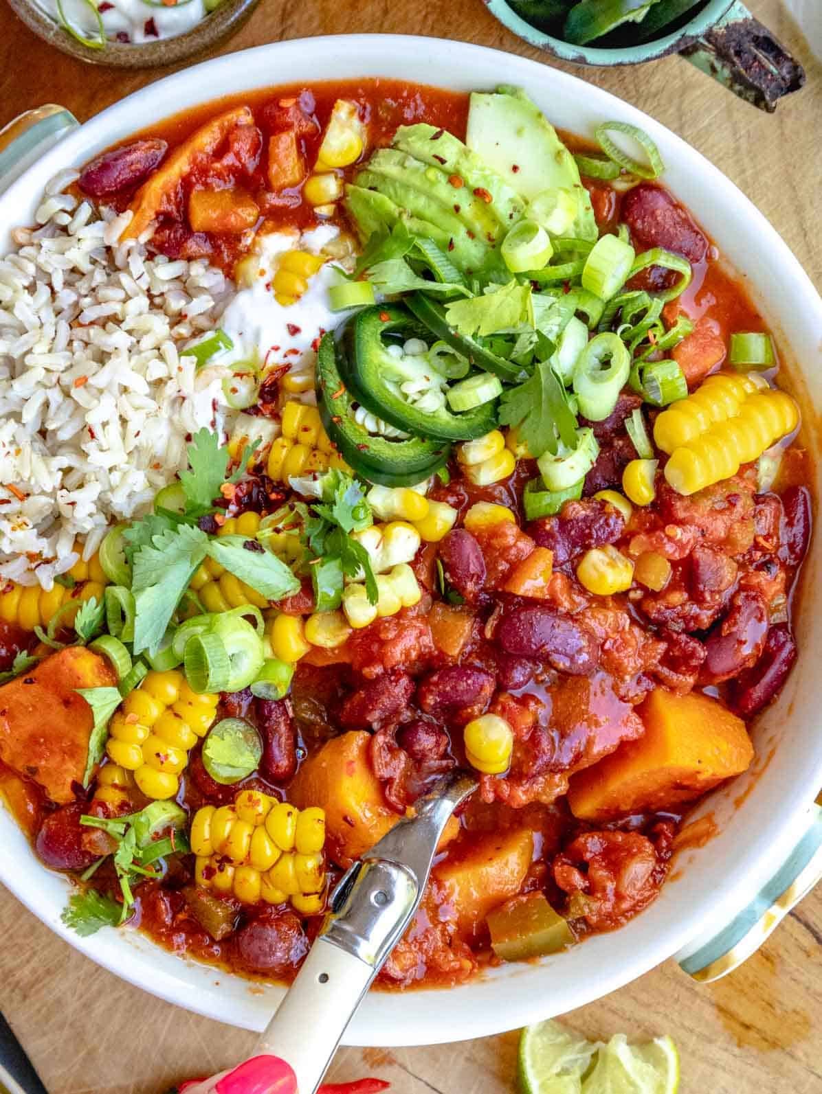 sweet potato chili with corn, cilantro, rice and a spoon