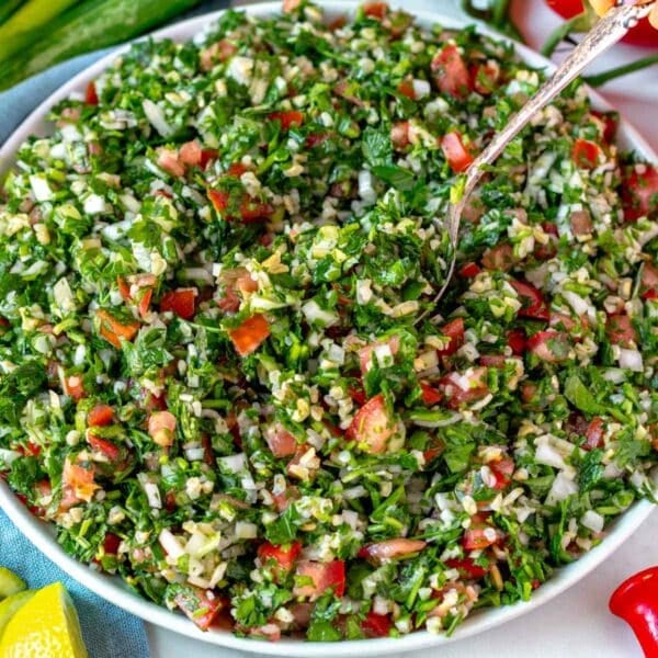 tabbouleh salad on a white plate with a silver spoon