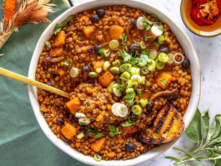 thick and earthy lentil stew serve in a bowl and a golden spoon